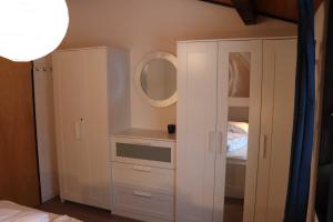 a bedroom with a white cabinet and a mirror at Ferienhaus Robinson Romantikpfad 161 in Waldbrunn