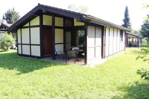 uma pequena casa com uma mesa num quintal em Ferienhaus Robinson Crusoe Schwarzkittelpfad 77 em Waldbrunn