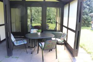 a screened in porch with a table and chairs at Ferienhaus Robinson Crusoe Schwarzkittelpfad 77 in Waldbrunn