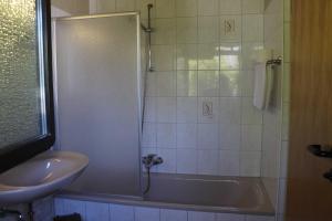 y baño con ducha, bañera y lavamanos. en Ferienhaus Robinson Romantikpfad 162 en Waldbrunn