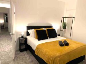 Schlafzimmer mit einem Bett mit schwarzen und gelben Kissen in der Unterkunft The Hughenden Townhouse / Free Parking / Wifi in Leicester
