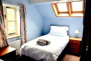 - une chambre bleue avec un lit et une serviette dans l'établissement Hafannedd Cottage - riverside views, à Corwen