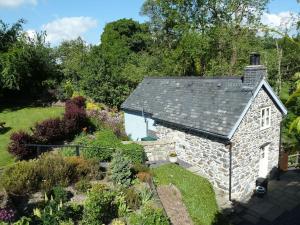 un cottage en pierre ancien dans un jardin dans l'établissement Hafannedd Cottage - riverside views, à Corwen