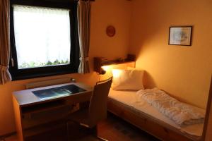 a room with a desk and a bed and a window at Ferienhaus Robinson Sonnenkreisel 133 in Waldbrunn