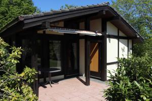 a pavilion with a table and a chair on a patio at Ferienhaus Robinson Sonnenkreisel 133 in Waldbrunn