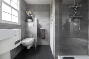 a bathroom with a toilet and a sink and a shower at Holiday Inn 48 Oisterwijk # Award 2024 in Oisterwijk