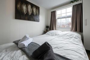 a white bed in a room with a window at Holiday Inn 48 Oisterwijk # Hygiëne # Airport Eindhoven # Airco # Bosrijk # Hiking & Biking # Efteling # Safaripark in Oisterwijk