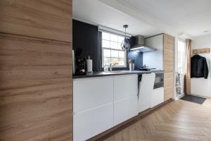 a kitchen with white appliances and a wooden wall at Holiday Inn 48 Oisterwijk # Award 2024 in Oisterwijk