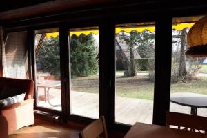 une véranda avec portes coulissantes en verre dans l'établissement Ferienhaus Winnetou Am Fuchsbau 67, à Waldbrunn