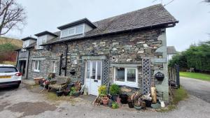 a stone house with plants in front of it at Cosy cottage in picturesque Hawkshead in Hawkshead