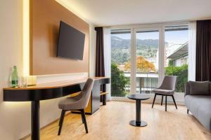 a living room with a table and a couch at Vienna House by Wyndham Martinspark Dornbirn in Dornbirn