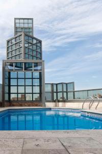 a building with a swimming pool in front of a building at NH Córdoba Panorama in Córdoba