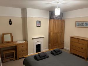 1 dormitorio con cama, escritorio y chimenea en Seastones, en Southwold