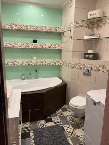 y baño con bañera, aseo y lavamanos. en Apartament w trójmiescie, en Kowale