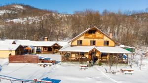 una cabaña de madera en la nieve con árboles nevados en Cabana Lunca, en Tîrgu Neamţ