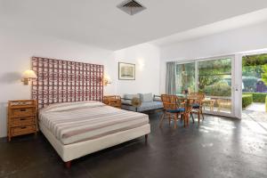 ein Schlafzimmer mit einem Bett und einem Tisch und Stühlen in der Unterkunft Dionysos Hotel in Ixia