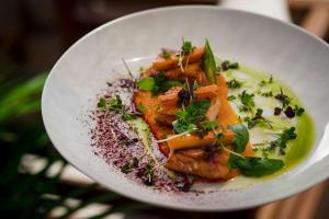 a white plate of food on a table at Rixos Premium Dubrovnik in Dubrovnik