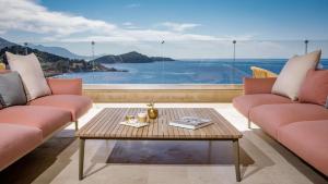 a living room with two pink couches and a table at Rixos Premium Dubrovnik in Dubrovnik