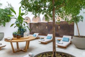 a patio with a table and chairs and a tree at Rixos Premium Dubrovnik in Dubrovnik