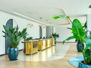 a lobby with potted plants and a row of counters at Rixos Premium Dubrovnik in Dubrovnik