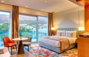 a hotel room with a bed and a large window at Rixos Premium Dubrovnik in Dubrovnik