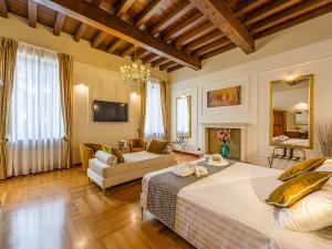 カプリーノ・ヴェロネーゼにあるHotel Villa Cariolaのベッドルーム1室(ベッド2台付)、リビングルームが備わります。