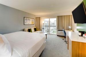 a hotel room with a bed and a desk with a television at Sonesta Select San Francisco Airport Oyster Point Waterfront in South San Francisco