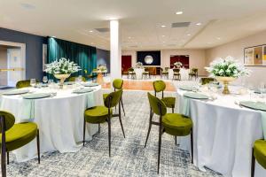 a conference room with tables and chairs with flowers at Sonesta Select San Francisco Airport Oyster Point Waterfront in South San Francisco