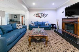 sala de estar con sofás azules y chimenea en Microtel Inn and Suites Lafayette, en Lafayette