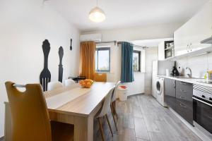 uma cozinha com mesa e cadeiras num quarto em Praia da Rocha Mar Guest House em Portimão