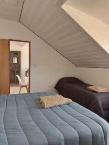 1 dormitorio con 2 camas y espejo en Cerro Chaltén House en El Chaltén