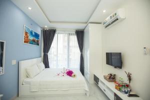 1 dormitorio con cama blanca y ventana en HOTEL & APARTMENT VY VAN, en Vung Tau