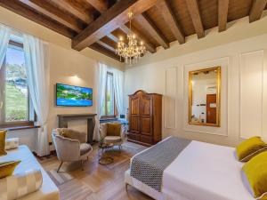 een slaapkamer met een kingsize bed en een open haard bij Hotel Villa Cariola in Caprino Veronese