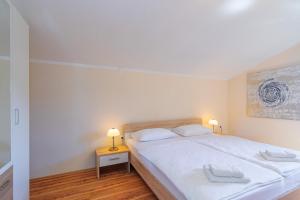 a bedroom with a white bed with two towels on it at Apartments Lina in Vrh +64 photos