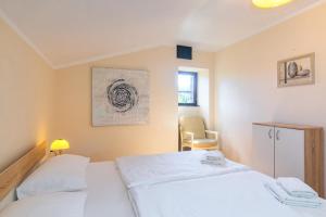 a bedroom with two white beds and a chair at Apartments Lina in Vrh