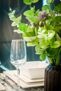 a table with a wine glass and a vase with flowers at Urban Bliss 2BR Enfield Hideaway - Cosy Spot - Free Parking & Wi-Fi in Enfield