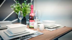 einen Tisch mit Tellern und Gläsern sowie eine Flasche Wein in der Unterkunft Urban Bliss 2BR Enfield Hideaway - Cosy Spot - Free Parking & Wi-Fi in Enfield