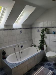 uma casa de banho com banheira e WC em Ferienwohnung Wiesenblick - a89952 em Scheggerott