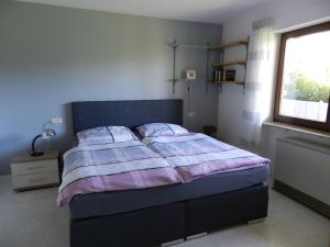 a bedroom with a bed with two pillows and a window at Ferienwohnung Schwendemann in Laichingen