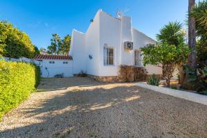 a white house with trees and a gravel driveway at Villa Anais - PlusHolidays in Calpe