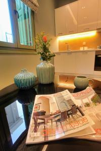 a kitchen with a table with a newspaper and a vase at Atsiki's 54 apartments in Chios