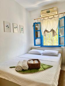 a bed with a basket of towels and a window at L'onda Oda Bodrum in Bodrum City