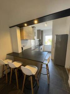 a kitchen with a black counter and chairs in it at Mulhouse, Urban Family Nest in Mulhouse +11 photos