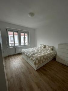 a white bedroom with a bed and a window at Mulhouse, Urban Family Nest in Mulhouse
