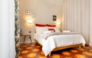a bedroom with a bed with white sheets and red pillows at Broggi 22 in Milan