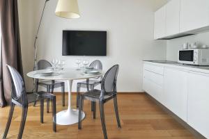Il comprend une cuisine avec une table et des chaises ainsi qu'une télévision. dans l'établissement ALTIDO Welcoming flats by Corso Como, à Milan