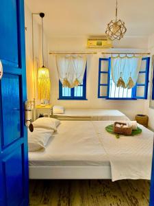 een slaapkamer met een groot wit bed en blauwe ramen bij L'onda Oda Bodrum in Bodrum City