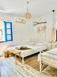 a white bedroom with two beds and a bench at L'onda Oda Bodrum in Bodrum City