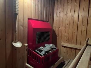 Zimmer mit rotem Heizgerät an einer Holzwand in der Unterkunft Gasthof Hotel zur Post in Egloffstein