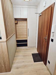 a small hallway with a door and a closet at Pine Point Apartament with shared Pools, Jacuzzi, Sauna & Gym in Szklarska Poręba